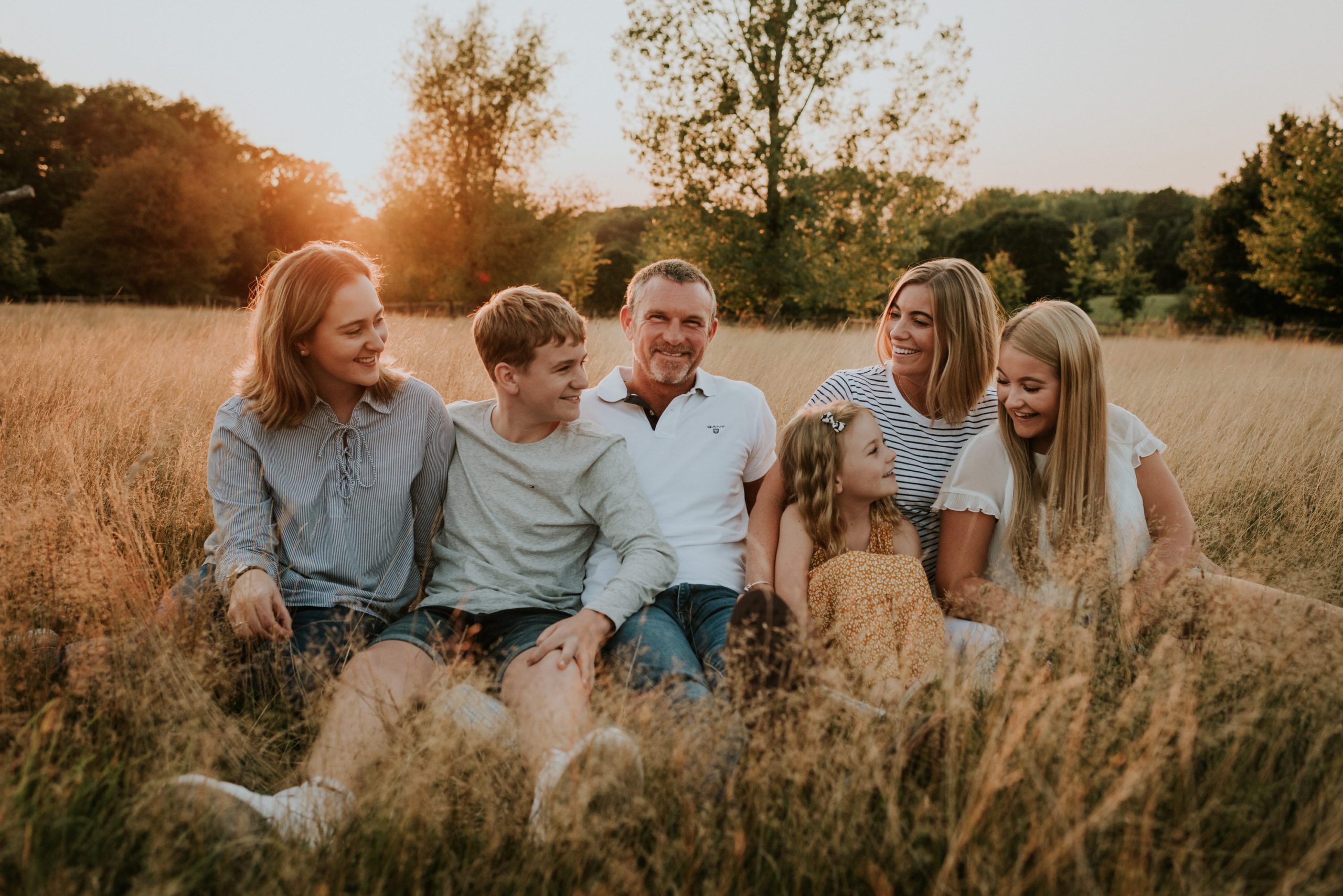 Family Sat Down in Field at Golden Hour